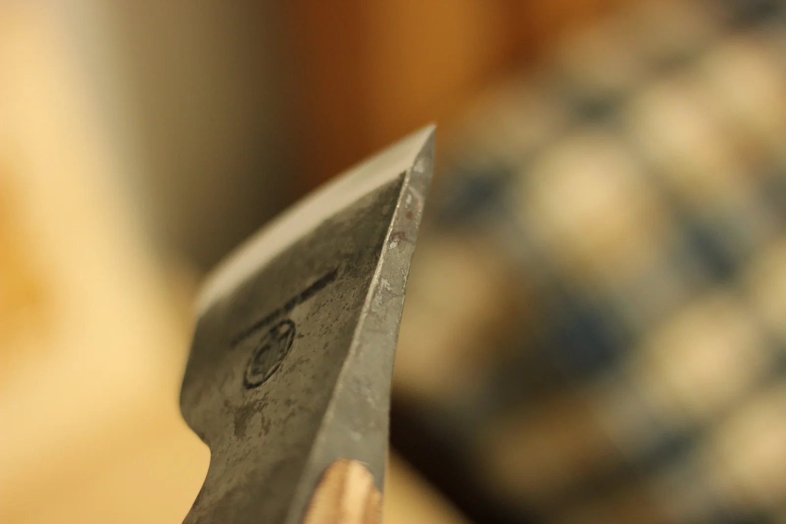 Side profile of the axe head from a low angle with the HB hallmark stamp visible just behind the polished cutting edge