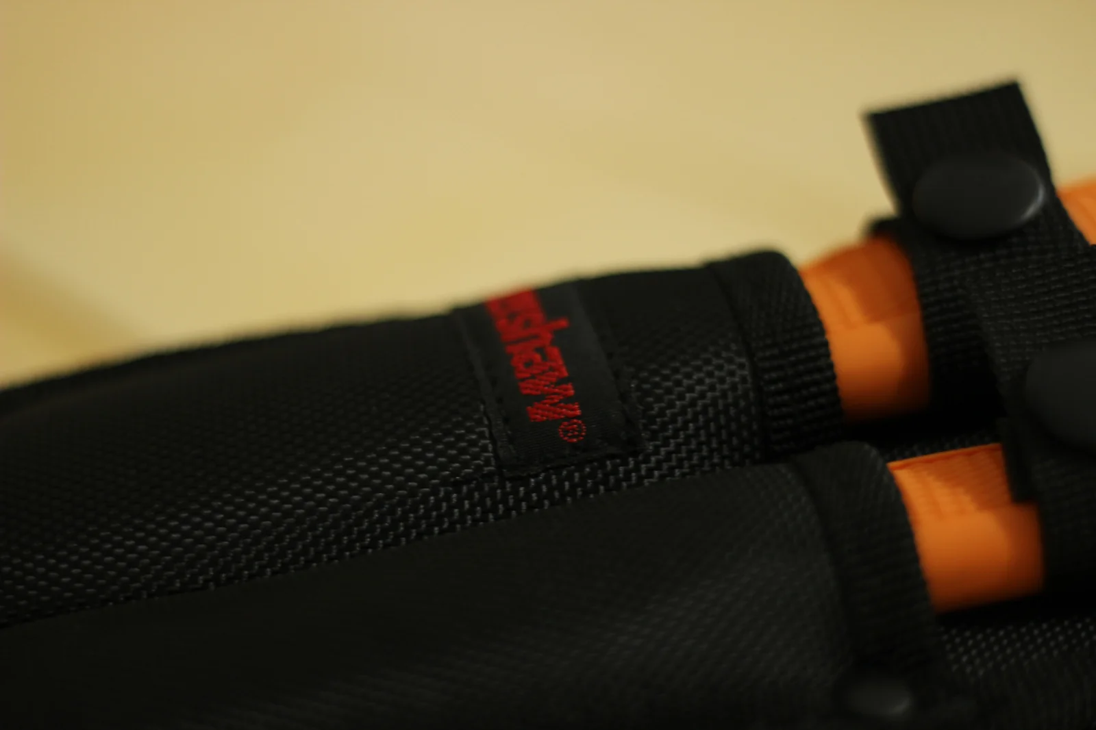 Macro of the red kershaw woven label sewn onto the front retention strap of the double sheath