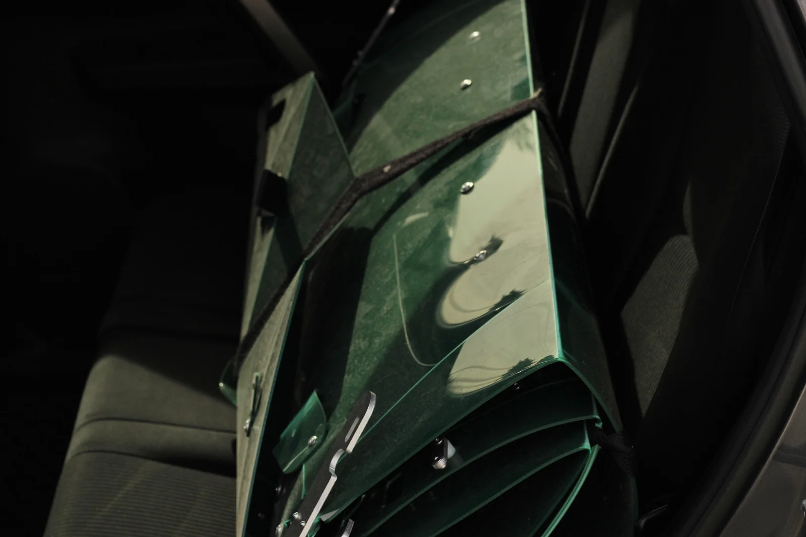 Folded Tucktec Pro kayak standing vertically behind the back seat of a passenger car