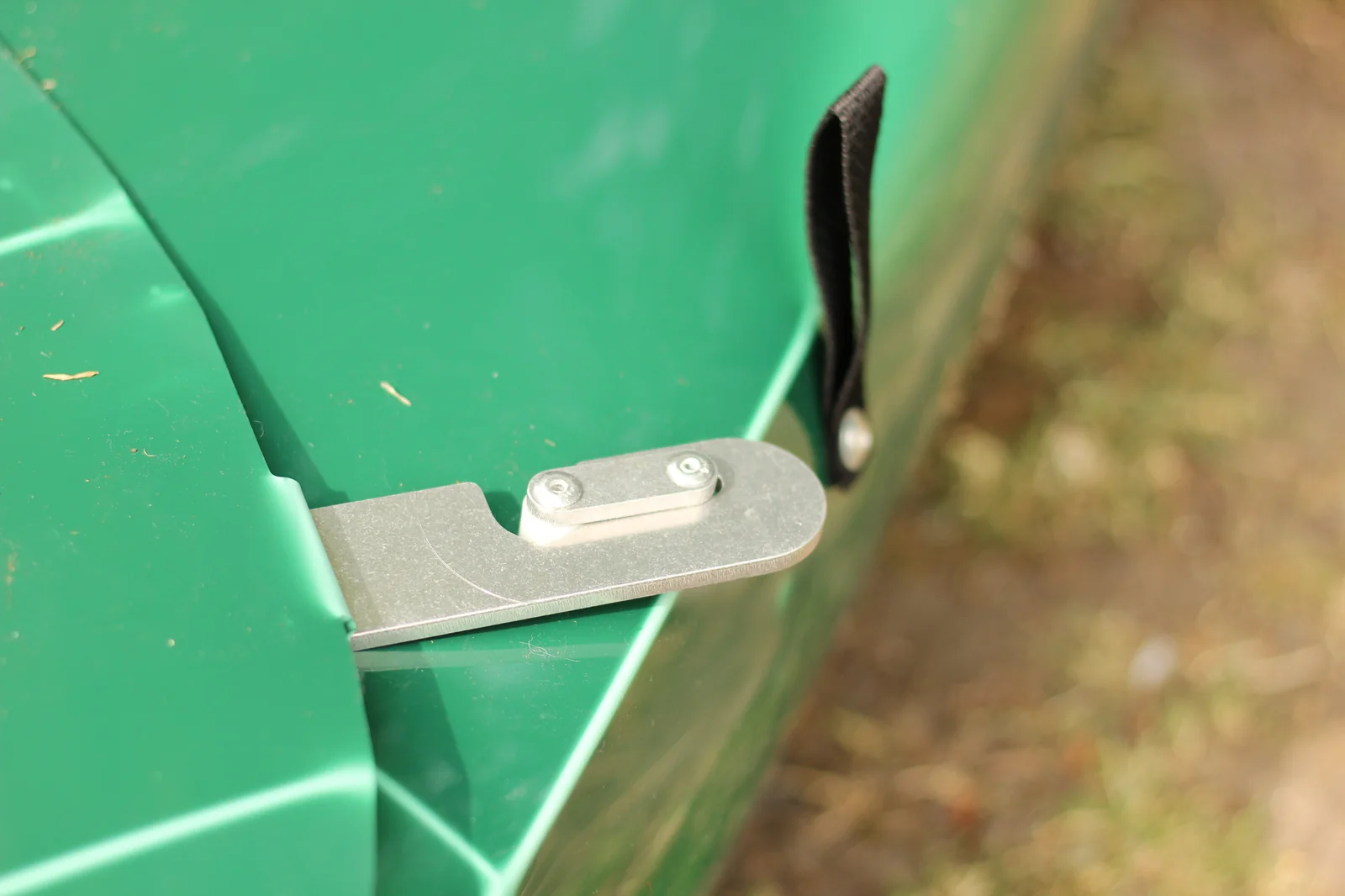 Close-up of the aluminum locking lever mounted on the edge of the green Tucktec hull